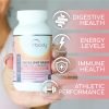 Hand holding bottle of total gut health prebiotic + probiotic supplement with text: digestive health, energy levels, immune health, athletic performance.