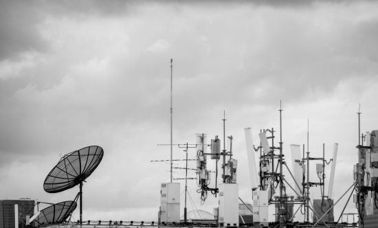 View of a roof and various types of antennas, a black and white photo.