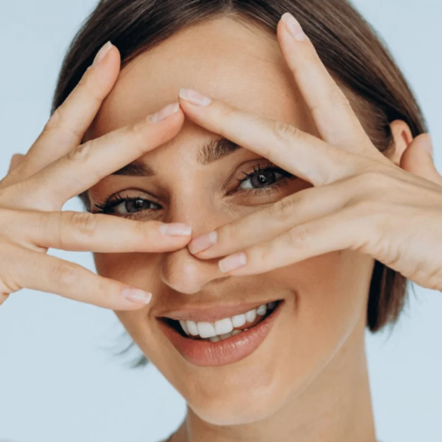 Woman with hands in her face around her eyes.